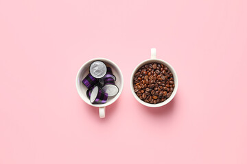 Cups with coffee capsules and beans on color background