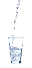 Pouring of water into glass on white background