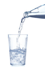 Pouring water from bottle into glass on white background