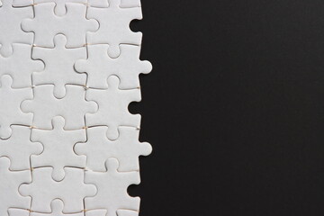 plain black background with white jigsaw puzzle for your content.