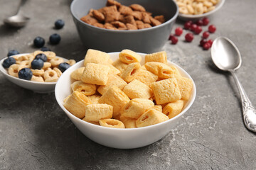 Different cereals and berries on grey background, closeup