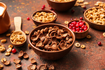 Bowls with different cereals and berries on grunge background