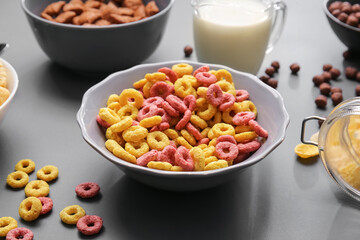 Different cereals and milk on dark background, closeup