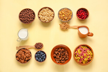 Frame made of different cereals, milk and berries on color background
