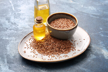 Plate with flax oil and seeds on color background
