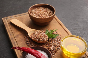 Composition with flax seeds, oil, sea salt and chili pepper on dark background, closeup