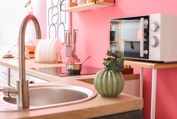 Modern microwave and electric stove in interior of stylish kitchen