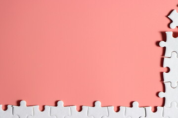 incomplete white jigsaw puzzle with plain pink background for your content