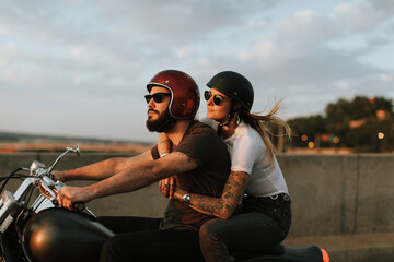Biker couple riding down the road in the sunset