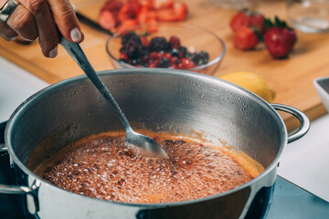 Woman Cooking Fruits and Making Homemade Jam.