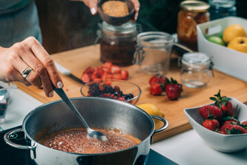 Woman Cooking Fruits and Making Homemade Jam.