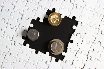 golden coins with incomplete white jigsaw puzzle and black background