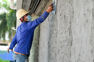 Plasterers using trowels mason for plastering and leveling mortar concrete on the brick wall at the...