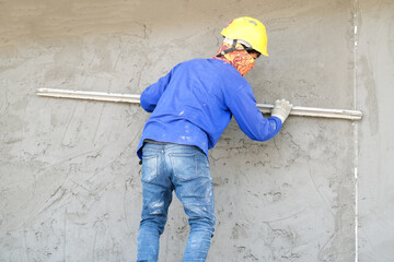 Plasterers using trowels mason for plastering and leveling mortar concrete on the brick wall at the...