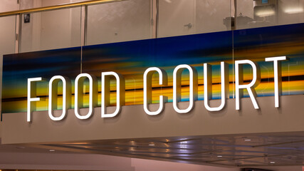 Neon sign read "Food Court" above the hallway in the airport terminal