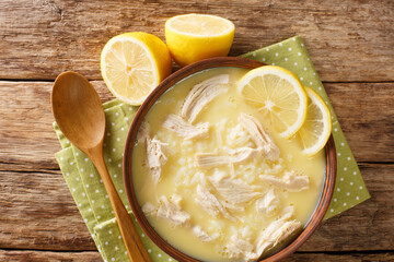 Chicken Soup with Eggs and Lemon Kotosoupa Avgolemono close up in the plate on the table. Horizontal top view from above