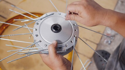 Technician man working motorcycle wheel has spokes weave up on mechanic new steel wheel, Motorcycle spokes wheel alignment