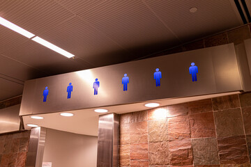 Blue neon men figures above restroom entry the the public restroom