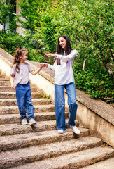A young mother with a small daughter walks down the stairs.