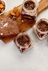 Trifles made with chocholate mousse and brownie on light gray background.