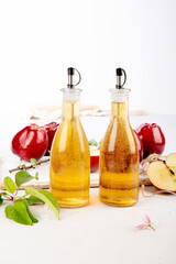 Apple cider vinegar and fresh apples on light background. Healthy organic food.