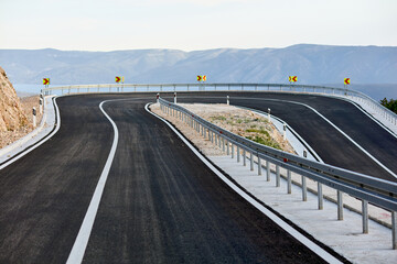 A 180-degree turn on an empty road by the sea. Island of Brac, Croatia. New, recently built asphalt...