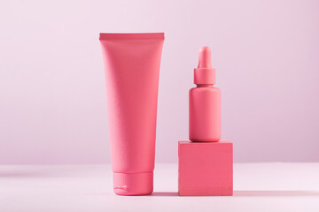 Mockup of pink containers for cosmetics, cream, serum, gel on a pink background. Copy space.