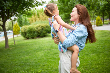Naklejka premium Happy Mother and her daughter playing in the park. Enjoying summer. Happy parenthood