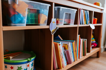 Shelves of toys and books in a nursery school - obrazy, fototapety, plakaty