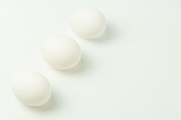 Three chicken eggs on a solid background
