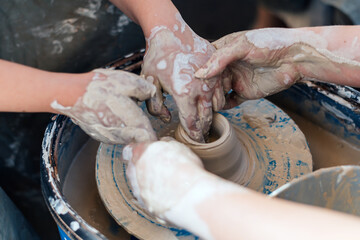 Master class on teaching pottery. Hands create a clay figure