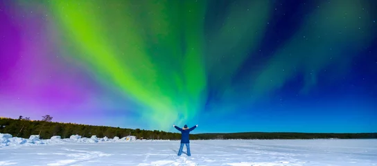 Fototapeten Northern lights travel tourism banner, man traveler looking at aurora borealis in night sky with stars © Parilov