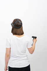 Woman in white holds black VR controllers. First in virtual reality wireless headset and system...