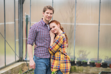 Fototapeta premium Happy woman touching confident man in greenhouse
