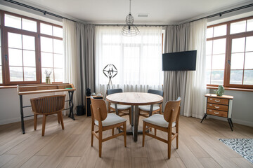 Room with three large windows and round table