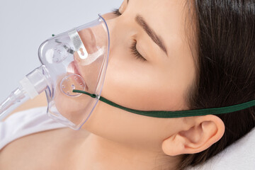 Young beautiful woman with oxygen mask in the hospital.