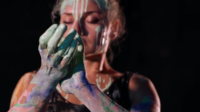 woman with paint on her hands and face dancing