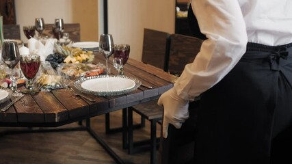 Waiter arrange set chairs furniture serving celebrate buffet table in restaurant. Female waiter preparing dinner table for festive banquet at catering