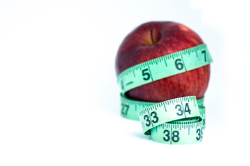 Blurred red apple with measuring tape isolated on white