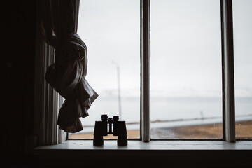 Binoculars on white windowsill