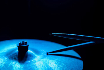 Close-up of drumsticks on a cymbal drum