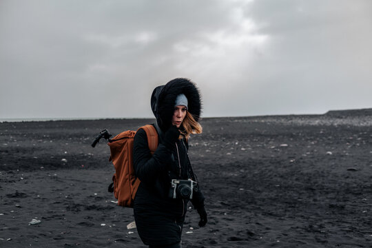 Female traveler with backpack in empty cold fields