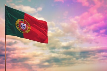 Fluttering Portugal flag mockup with the space for your content on colorful cloudy sky background.