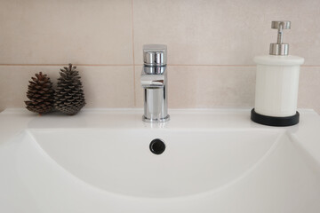 Bathroom countertop with bottle of hand gel and ornaments. Close up and front view