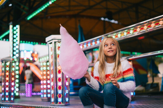 Cute lonely girl holding a cotton candy