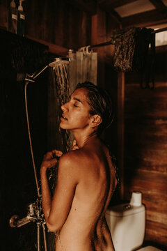 Young slim woman taking shower
