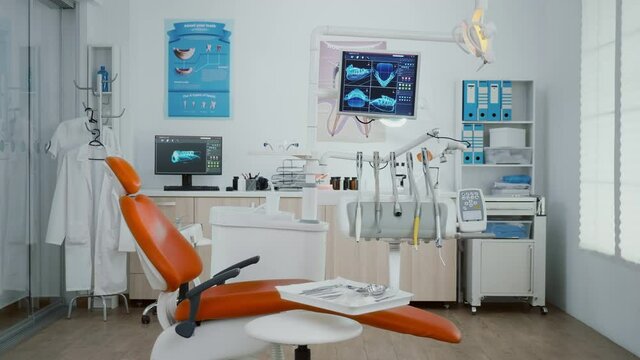 Zoom in shoot of stomatology orthodontist office room with tooth xray images on monitor ready for dental surgery. Orthodontic dentistry workplace equipped with dentist chiar and teeth instruments