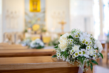 Fototapeta na wymiar Beautiful church decorated of white flowers in church for wedding or first communion ceremony