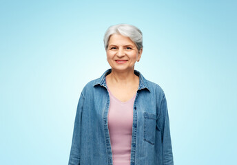 old people concept - portrait of smiling senior woman in denim shirt over blue background