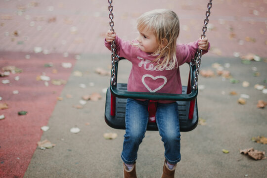 Happy Little girl swinging in a playground